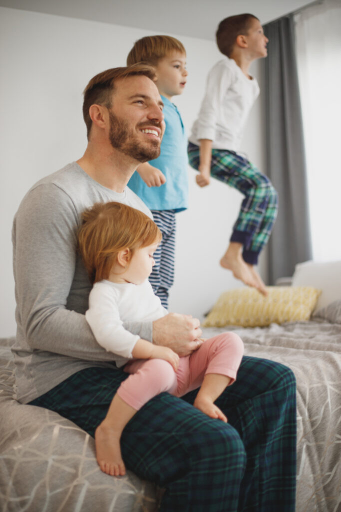 Vader met zijn kinderen op bed